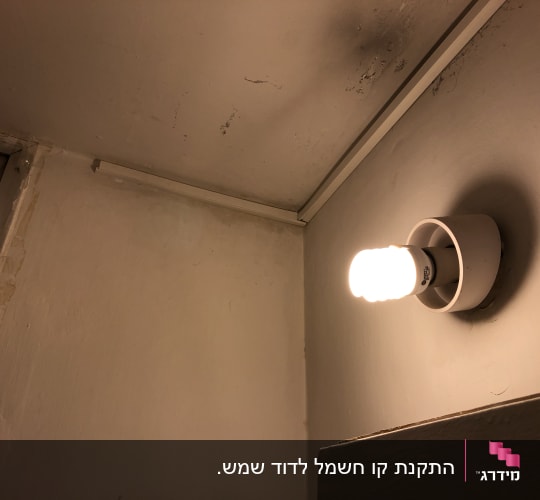 נורה דולקת על קיר עם חוטי חשמל